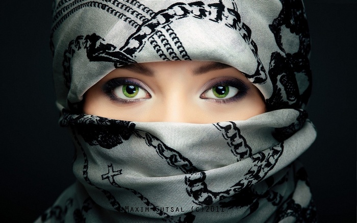 Woman with green eyes wearing a patterned headscarf