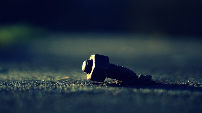 Close-up of a metal bolt and nut on the ground