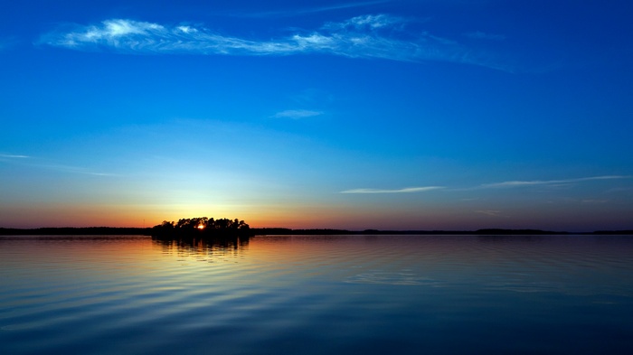 Sunset over a calm lake with an island