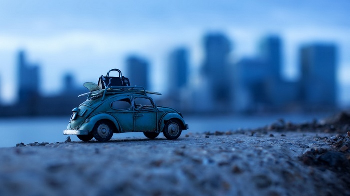 Toy car with surfboard and luggage on roof
