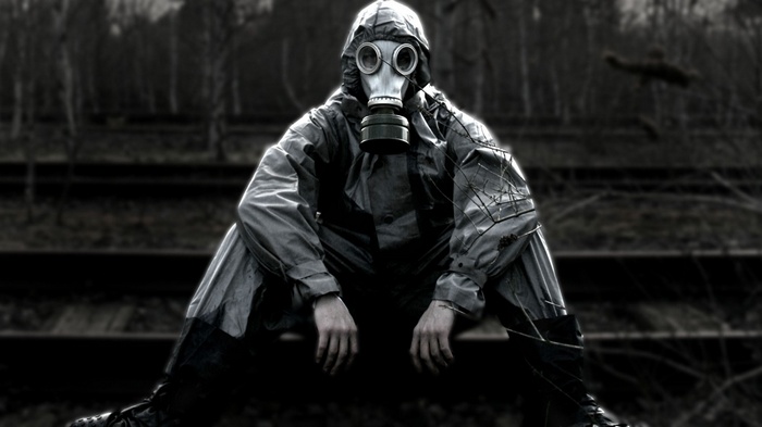 Person in gas mask on railway tracks