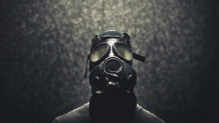 Person wearing a gas mask in an apocalyptic setting