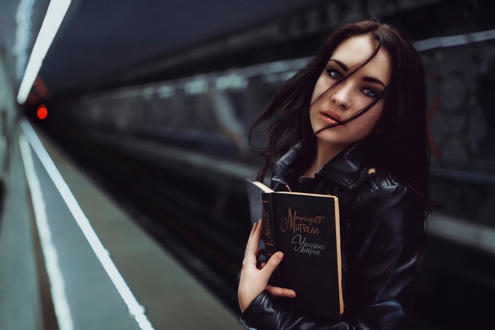 Woman holding a book in a subway