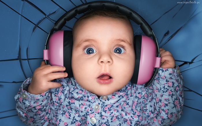 Baby with blue eyes wearing pink headphones