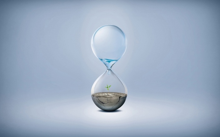 Hourglass with water and a plant growing