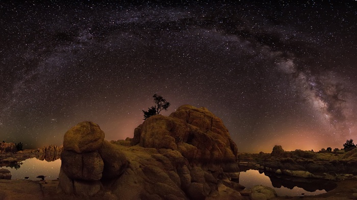 Milky Way over rock formations and a small lake