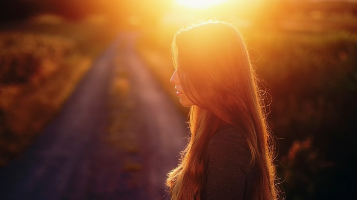 Woman with long hair in profile at sunset