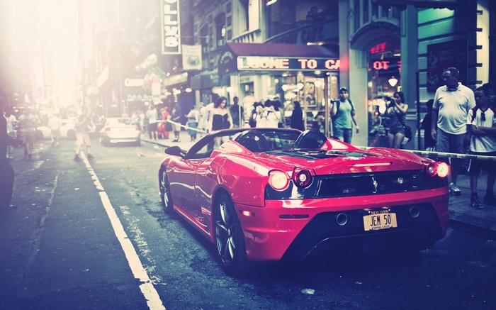Red Ferrari sports car on a city street