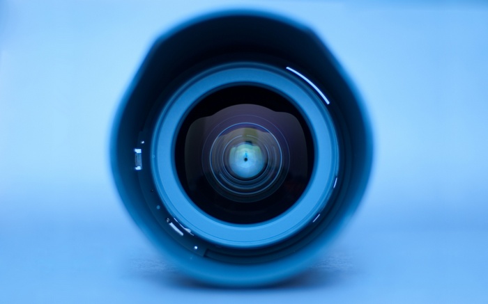 Close-up of a camera lens with blue background
