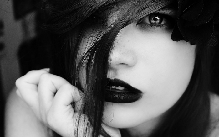 Monochrome portrait of a woman with black lipstick and hair in face