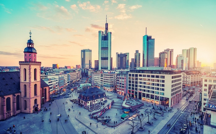 Frankfurt cityscape with church and skyscrapers at sunset