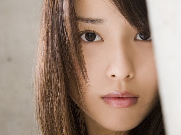 Erika Toda peeking from behind a white surface