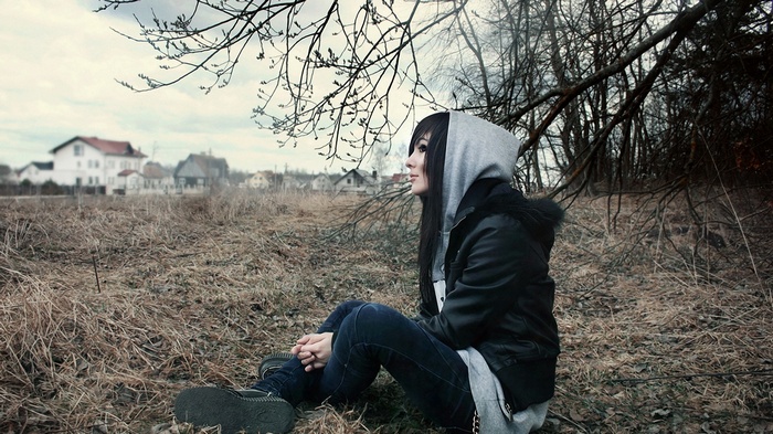 Woman with dark hair sitting outdoors in profile