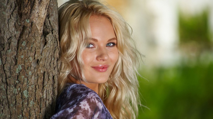 Talia Cherry leaning against a tree