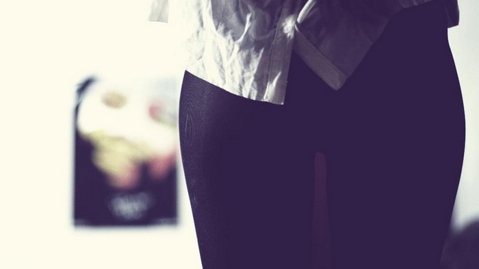 Woman wearing black pantyhose and a white shirt