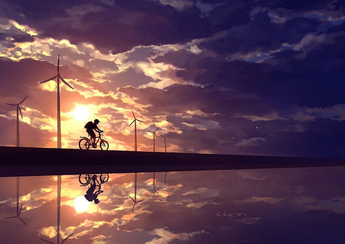 Silhouette of a cyclist with wind turbines at sunset