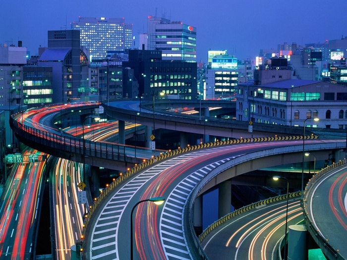 Tokyo highway interchange with light trails at night