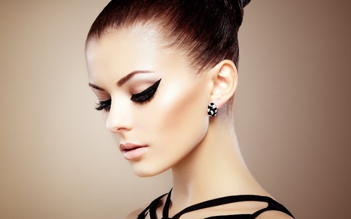 Woman with dramatic makeup and earrings