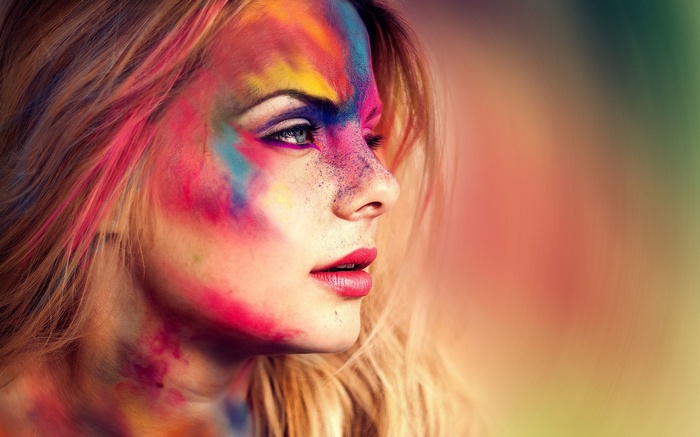 Woman with colorful face paint in profile