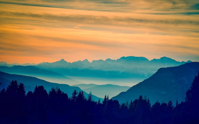 Mountain range at sunset with orange sky