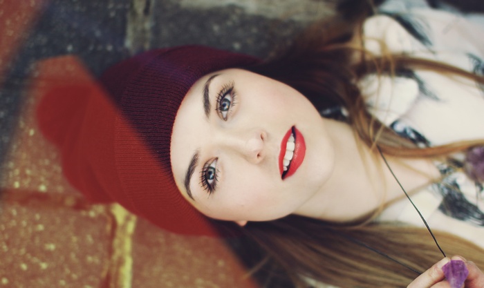 Woman with blue eyes and red lipstick wearing a hat