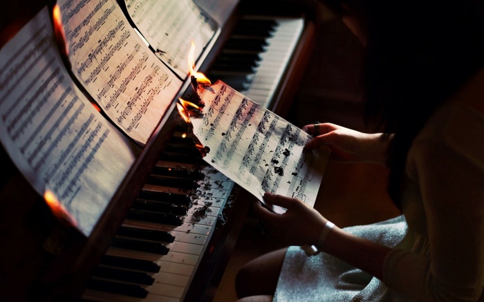 Sheet music burning on a piano