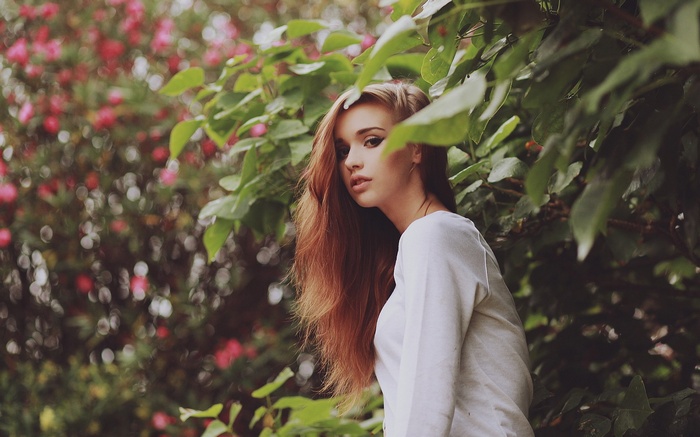 Woman with long hair in a white top outdoors