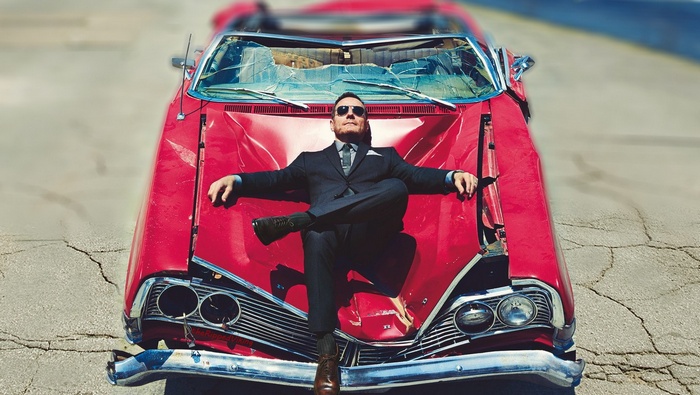 Bryan Cranston as Heisenberg lying on a red car