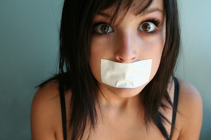 Woman with white tape over her mouth
