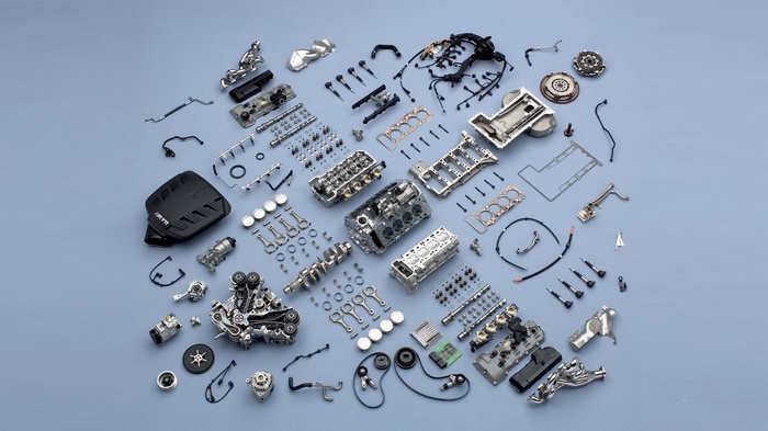 BMW engine parts laid out on a blue background
