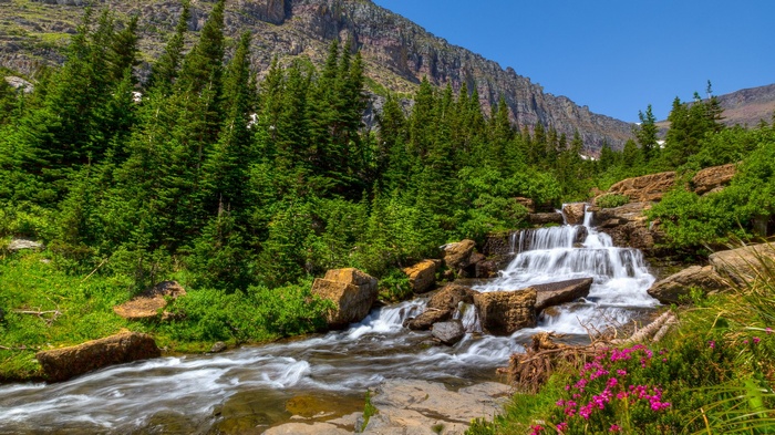 Waterfall cascading through rocks and trees in a mountain landscape
