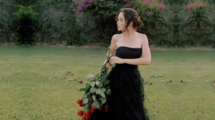 Alexis Bledel in a black dress holding roses