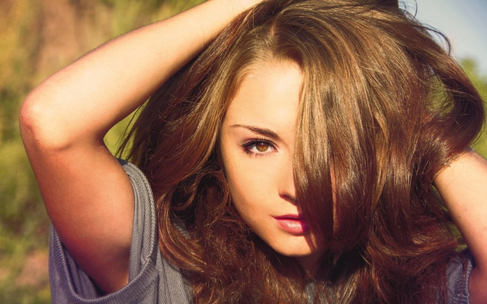 Woman with brown hair and brown eyes outdoors