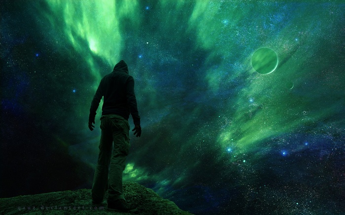 Man in hoodie looking at green nebula and planets