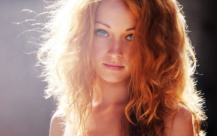 Redhead woman with blue eyes in sunlight