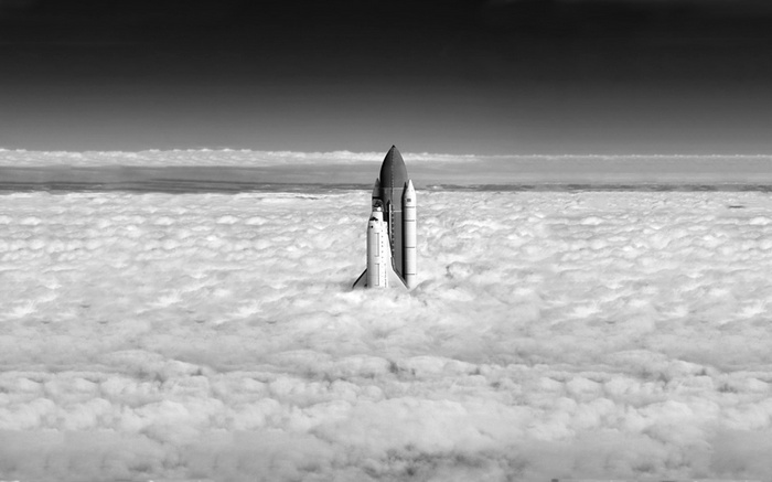Space shuttle emerging from clouds