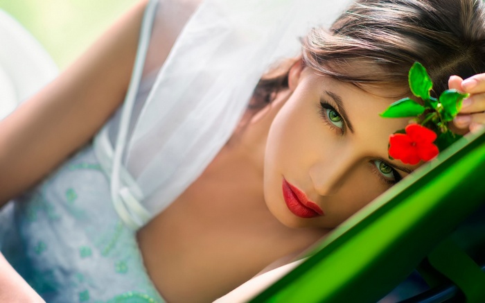 Woman with red flower and green eyes