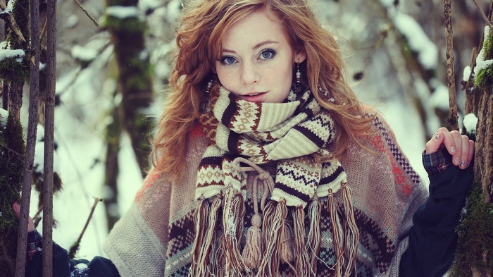 Redhead woman in winter forest wearing a scarf