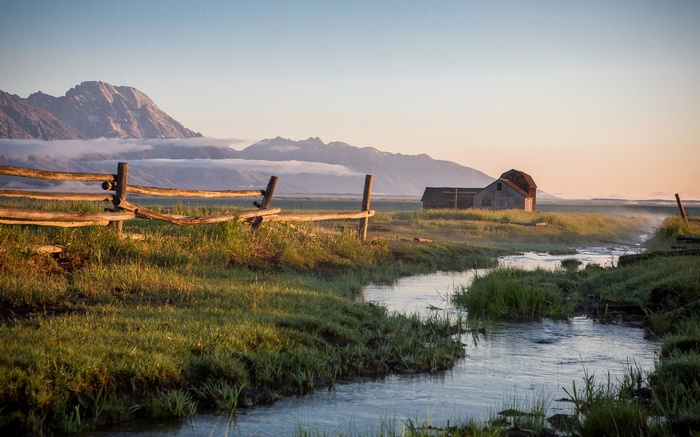 Barn and fence in a mountain landscape at sunrise