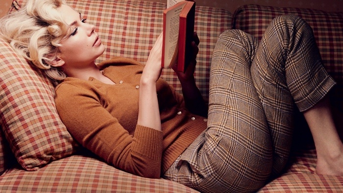 sweater lying on back books reading blonde couch women indoors legs crossed women pants long hair Michelle Williams lying down curly hair actress