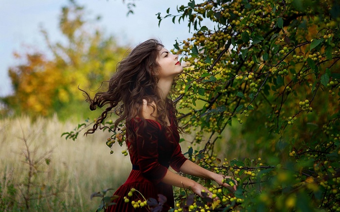 Woman in red dress near fruit tree