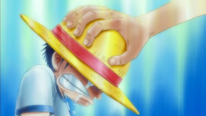 Monkey D. Luffy crying as Shanks places hat on him
