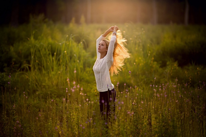 Woman with arms up in a field of flowers
