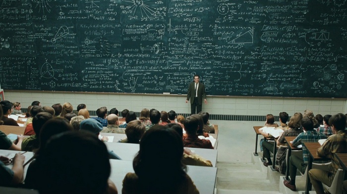 Professor teaching math to students in a classroom