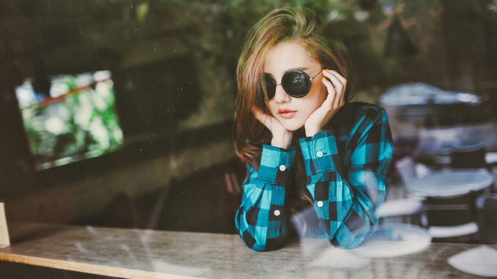 Woman with sunglasses wearing a plaid shirt