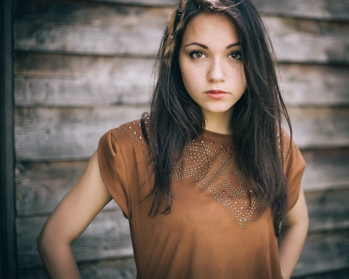 Brunette woman with dark hair and brown shirt