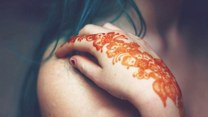 Woman with teal hair and henna tattoo on hand
