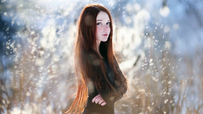 Redhead woman with long hair in a snowy outdoor setting