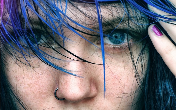 Close-up of a person with blue hair and blue eyes