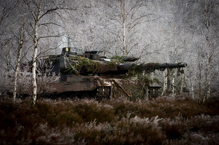 Leopard 2 tank camouflaged in a frosty forest